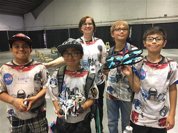  Killip students stand with teacher and robot.